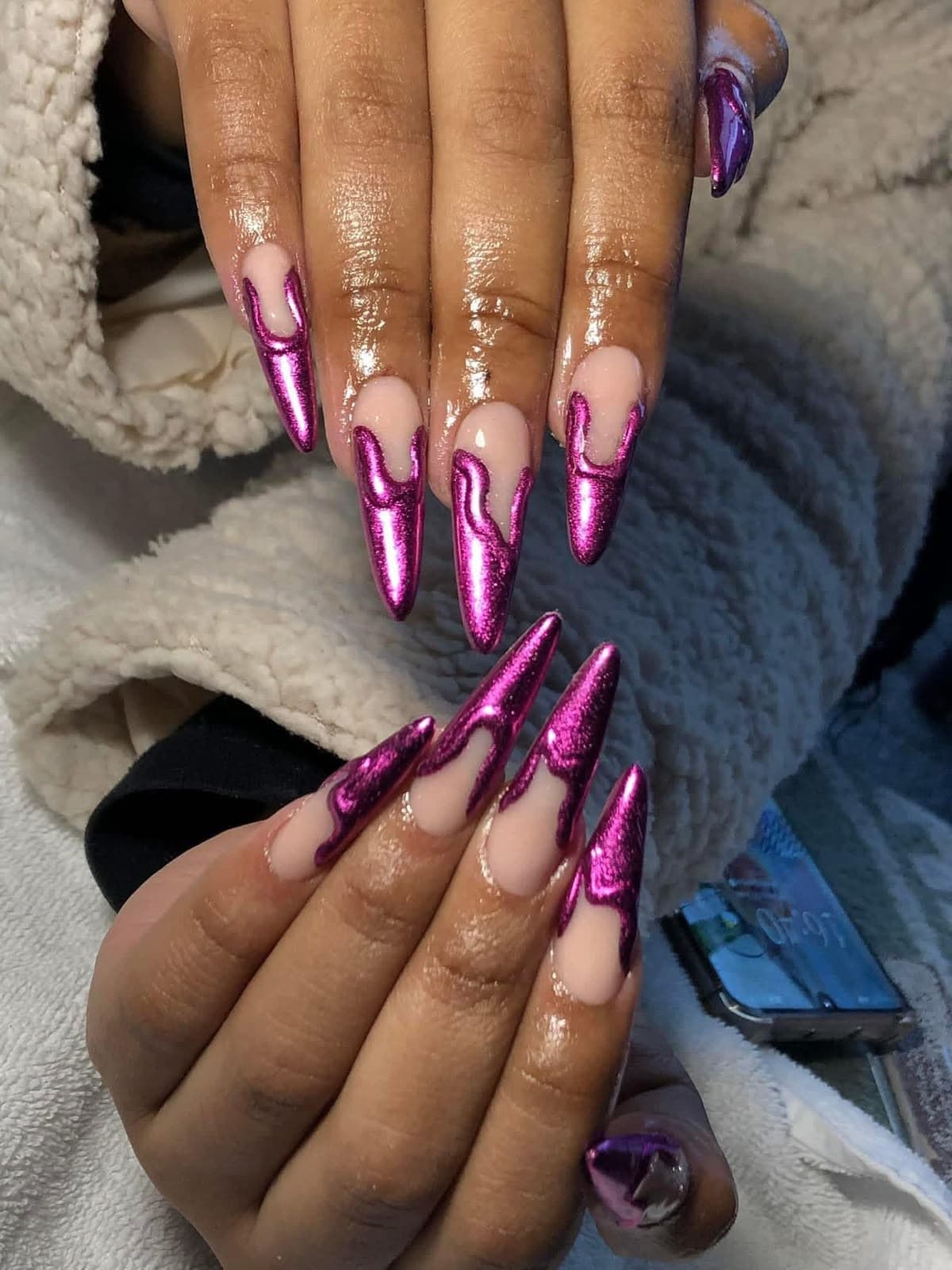 Long almond and stiletto nails with magenta chrome drip design on a nude base