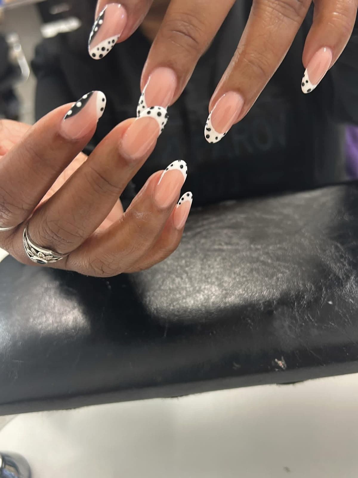Almond nails with black and white polka dot French tips